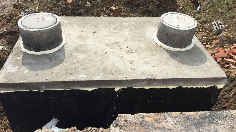 Dvojkomorová betónová žumpa, pripravená na pripojenie potrubia